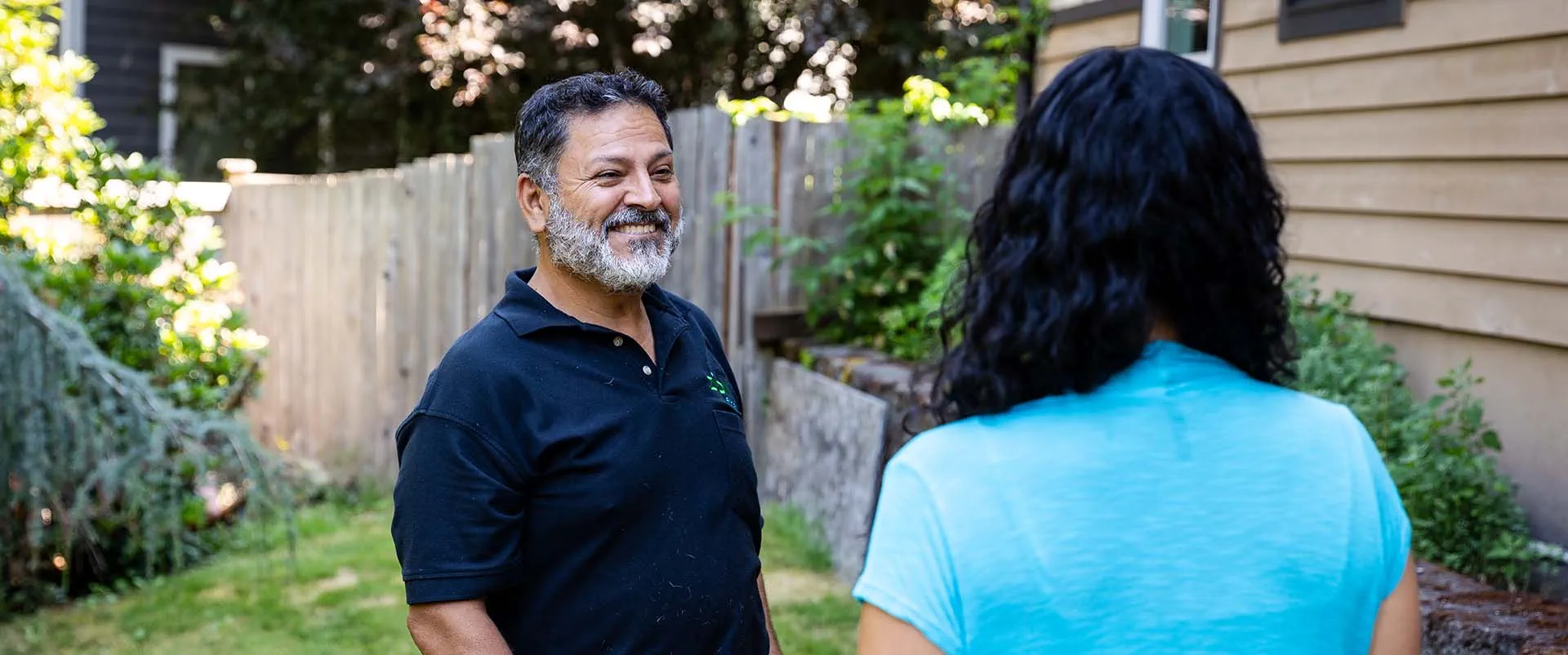 A couple of homeowners check the back yard of their new property where they recently scheduled new fiber installation. 