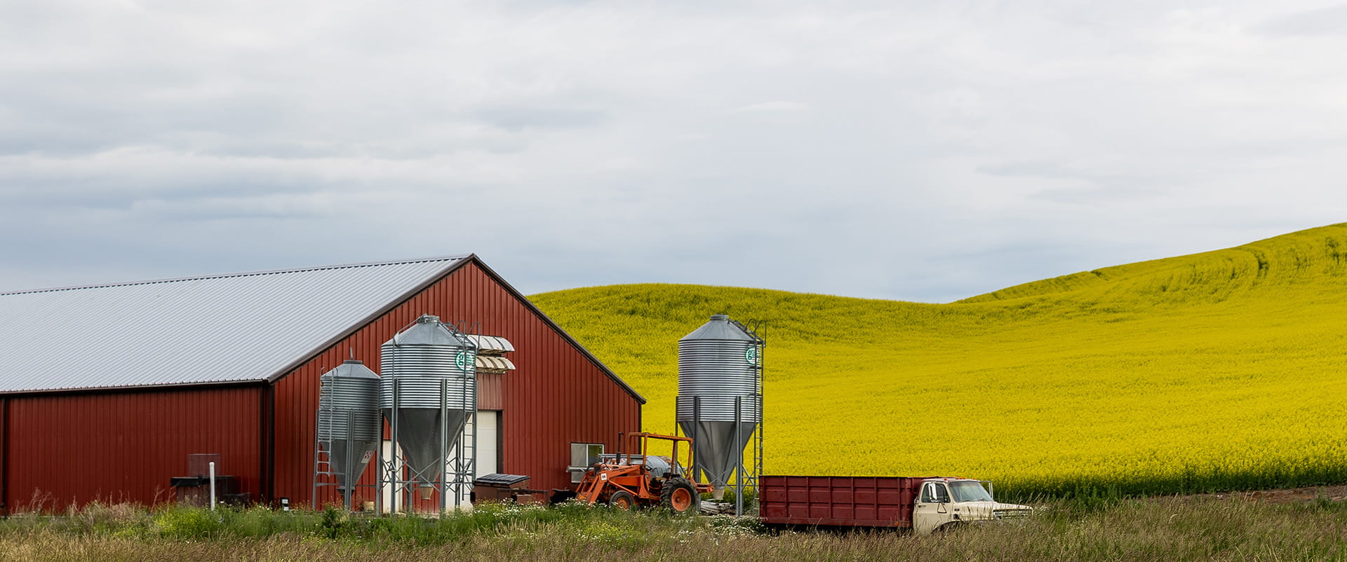 Landscape photograph of a barn and rolling hills in Idaho, where many underserved residents eagerly await the arrival of fiber-optic technology. 