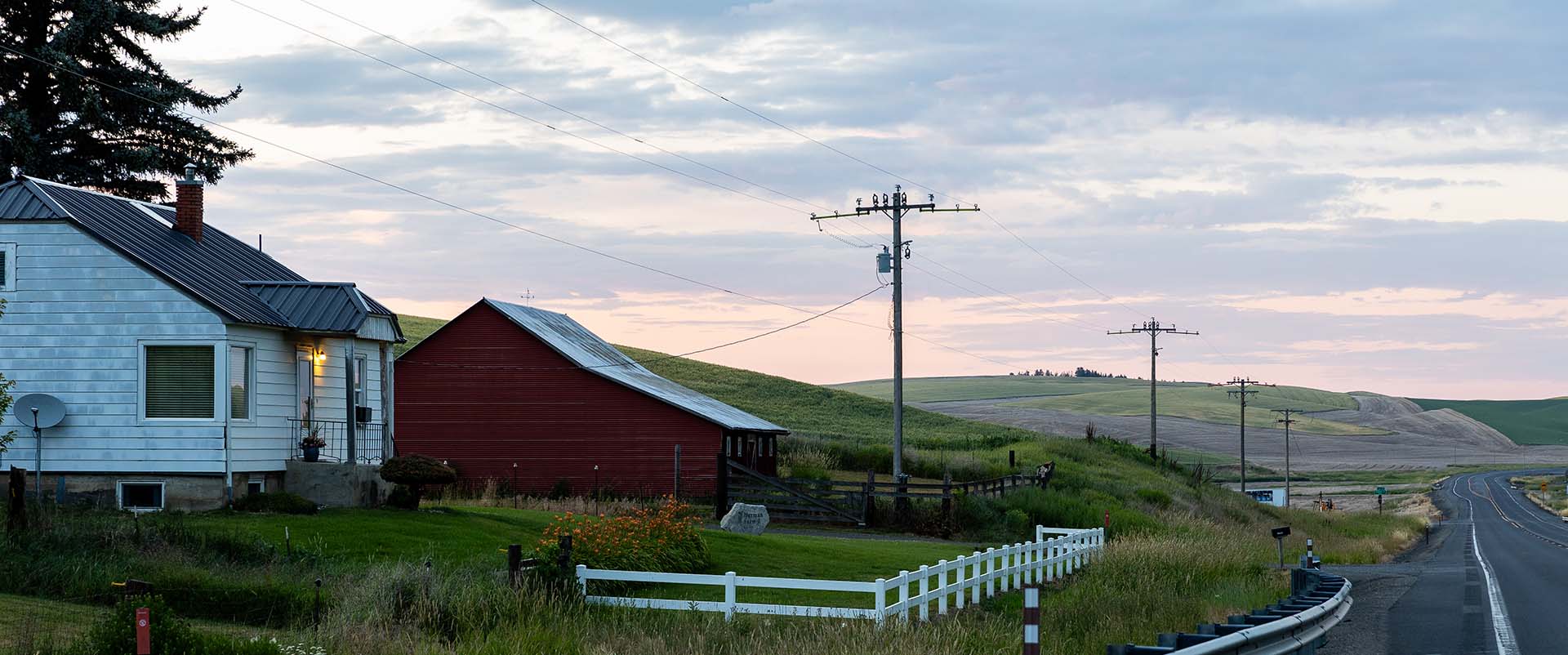 Photo of house and barn on gently rolling hills where residents often experience the digital divide 