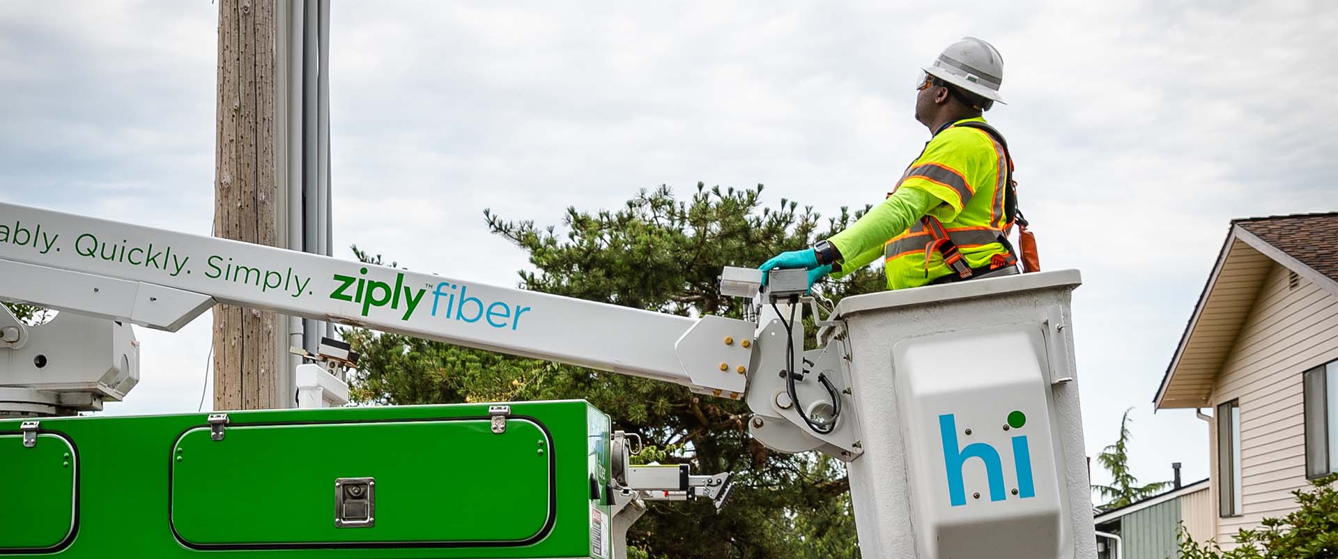 Ziply Fiber technician assesses an aerial line from a construction bucket