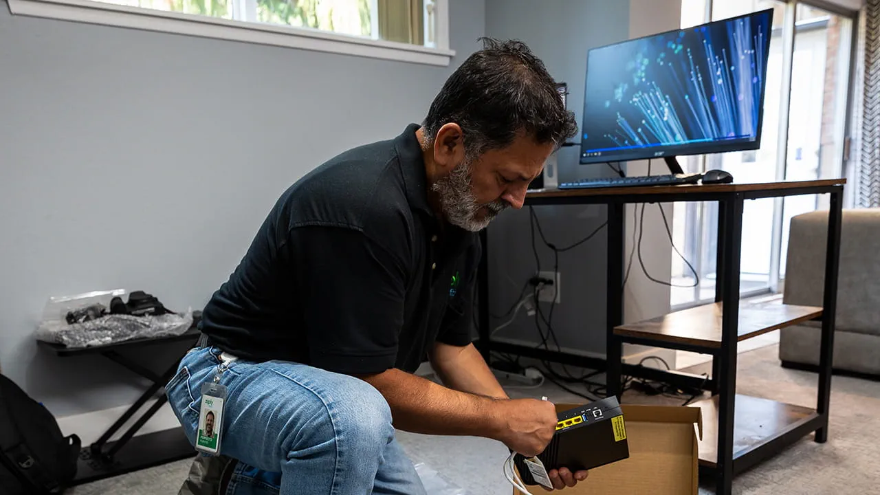 Ziply Fiber technician setting up a router to deliver fast fiber internet to a new customer