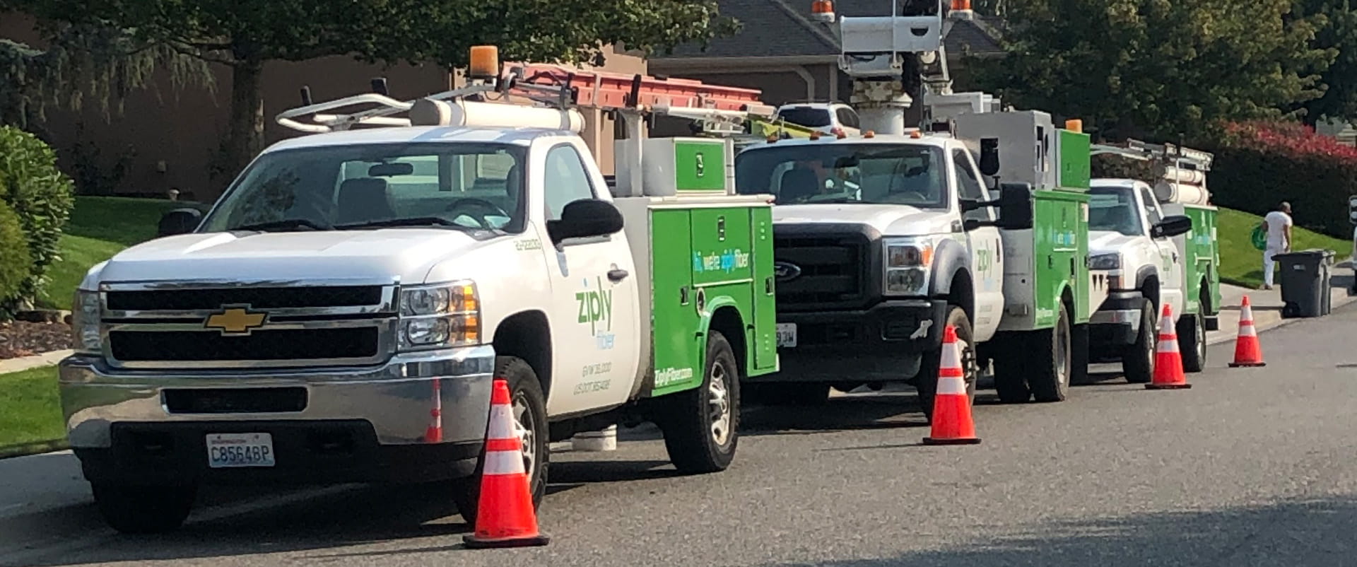 Row of Ziply Fiber construction trucks on site for internet installation