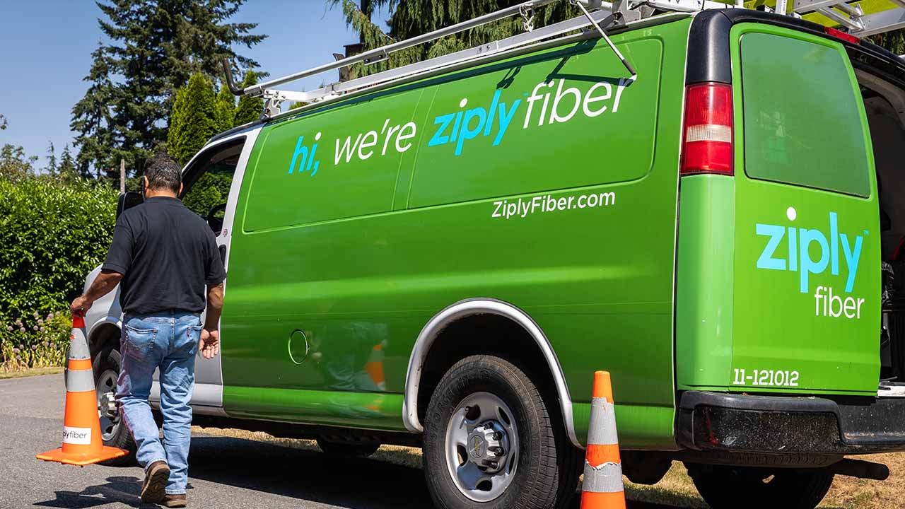 Ziply Fiber technician carries a traffic cone to a Ziply Fiber van