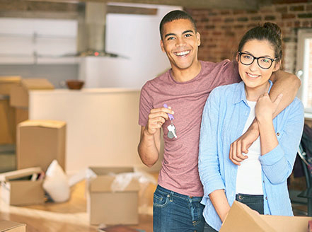 Couple smiling in front of moving boxes
