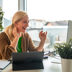 Professional leads a video call while referencing notes on a tablet, all connected seamlessly over fast fiber internet. 