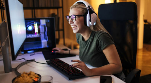 Person wearing gaming headset in front of desktop computer screen 