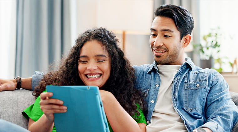 Couple using a device on couch