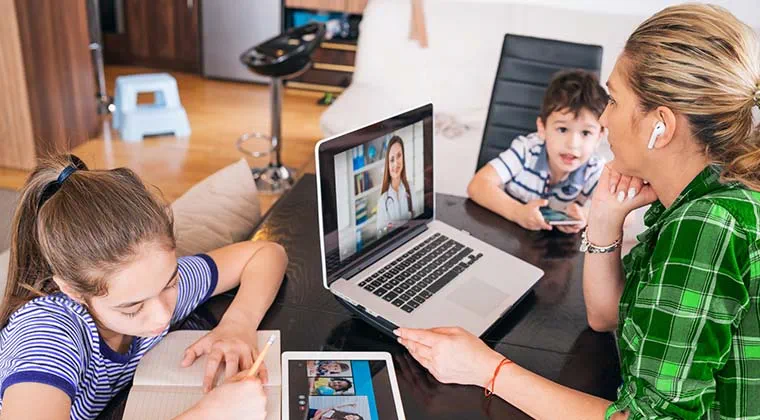 Busy Mom joins a telemedicine appointment while the kids work on different devices, all seamlessly connected with no buffering, via fiber-optic internet. 