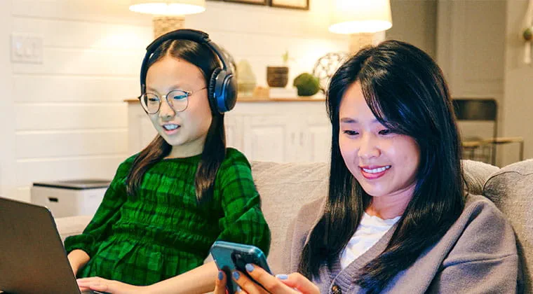 A couple of friends hang out with their devices connected to 5 Gig internet, which supports a wide range of high-bandwidth activities simultaneously. 